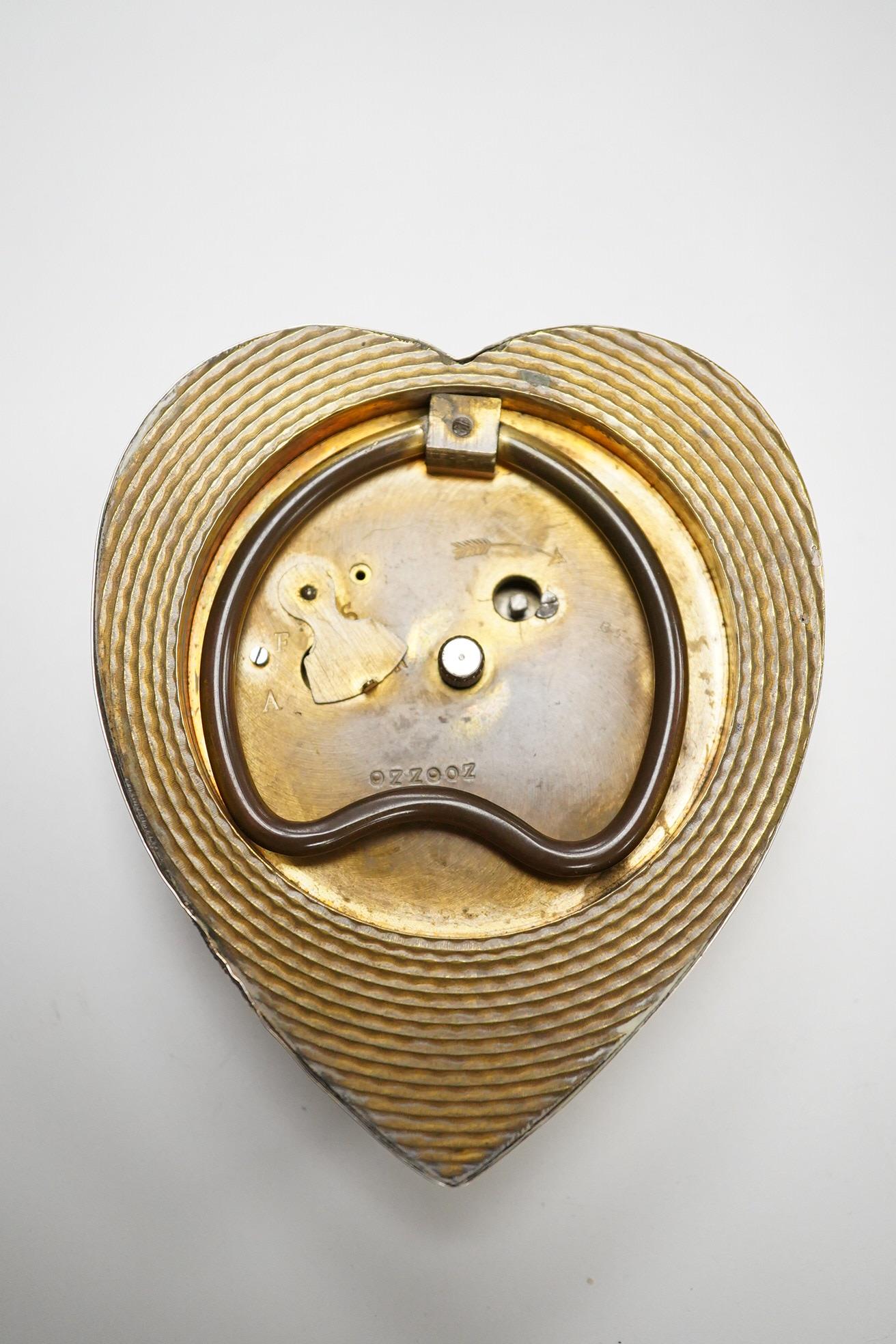 A late Victorian repousse silver mounted brass heart shaped bedside timepiece, with Arabic dial and subsidiary seconds, Douglas Clock Co. Birmingham, 1900, 94mm.